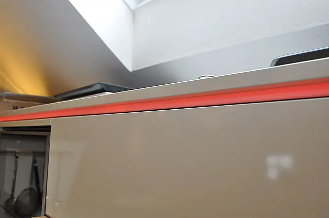 Moderne grifflose Hochglanz-Küche mit Insel und Dekton-Arbeitsplatte