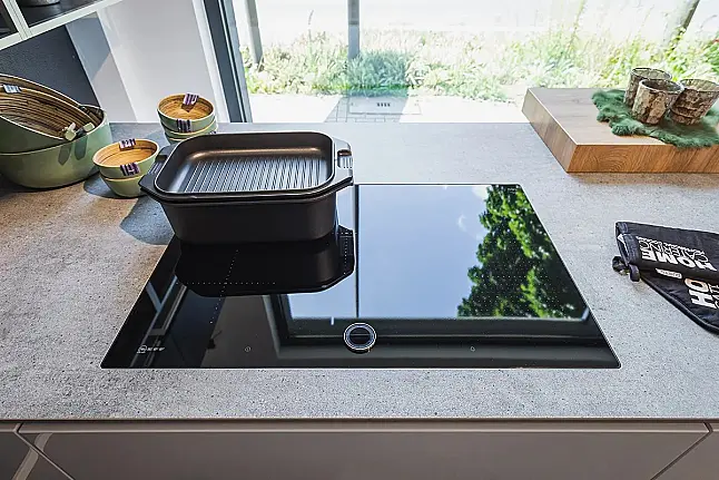 moderne, puristische Design-Küche mit Koch- und Spülen-Insel mit Stein-Arbeitsplatte und Pultplatte in Eiche Hirnholz natur Repro, sowie Einbau-Kühl-Gefrier-Kombination und hochgebautem Backofen und Dampfgarer