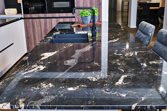 Koje 48 KH: Grijze hoekkeuken met notenhout, bar en granieten werkblad
