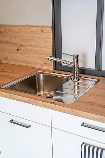 Zeitlose Design Küche in L-Form in Kristallweiß Mattlack, durchdachte Stauraumlösungen und hochwertige Markengeräte