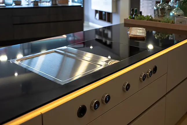 Musterküche perlgrau grifflos mit Feineiche natur und Quarzstein Arbeitsplatte in "Legend Black"