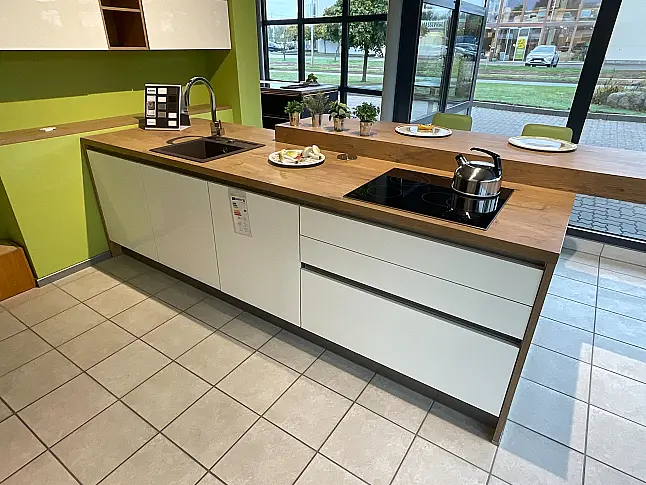 moderne Einbauküche mit hellen glänzenden Fronten abgesetzt mit Holzdekor und Kochinsel