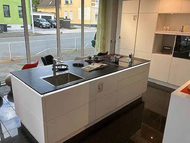 Exklusive grifflose Musterküche  In Kristallweiss Mattlack mit Granitkücheninsel