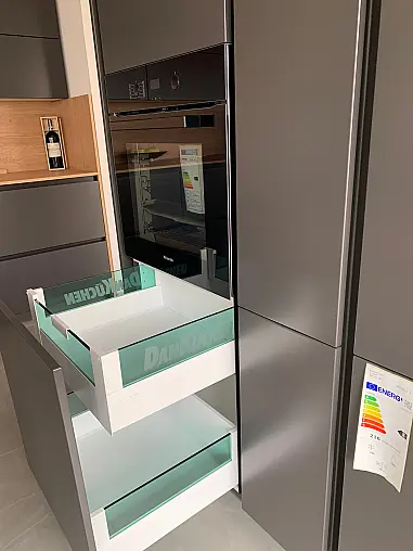 Elegante DAN Ausstellungsküche mit Kochinsel, Keramik-Arbeitsplatte, Bosch Muldenlüfter und versenkbarer Steckdose. Sofort verfügbar und deutlich reduziert.