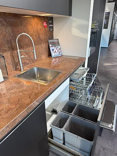 Designküche mit Organicglas-Fronten Naturstein-Arbeitsplatten und Kochinsel