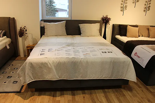 Hohes gemütliches Bett mit Kopfteil in klassischem Grau