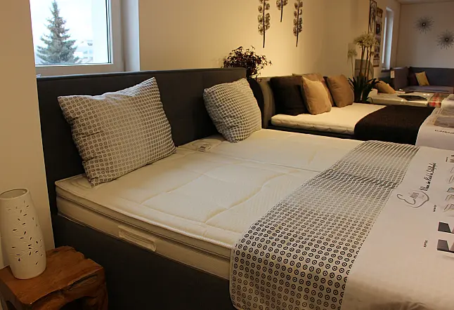 Hohes gemütliches Bett mit Kopfteil in klassischem Grau