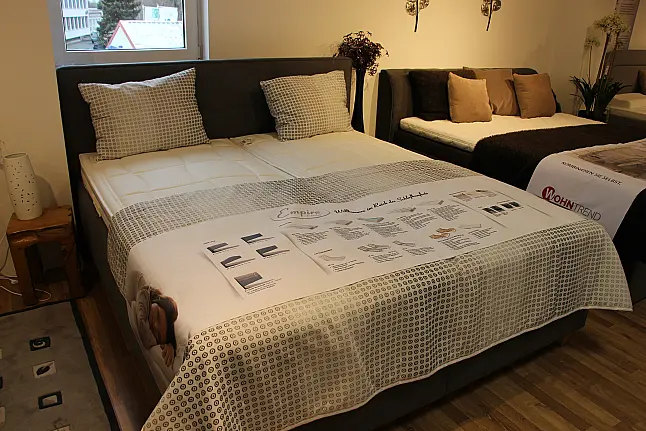 Hohes gemütliches Bett mit Kopfteil in klassischem Grau