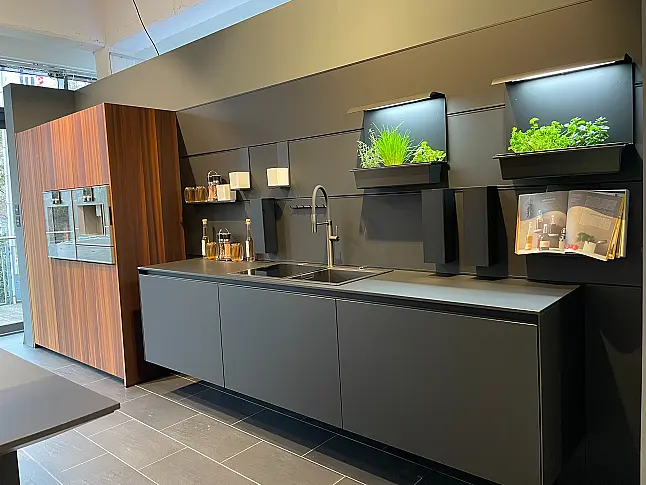 Schwarze Küche mit Hochschränken in geräucherter Lärche und einem Wandhängendem Spülenschrank