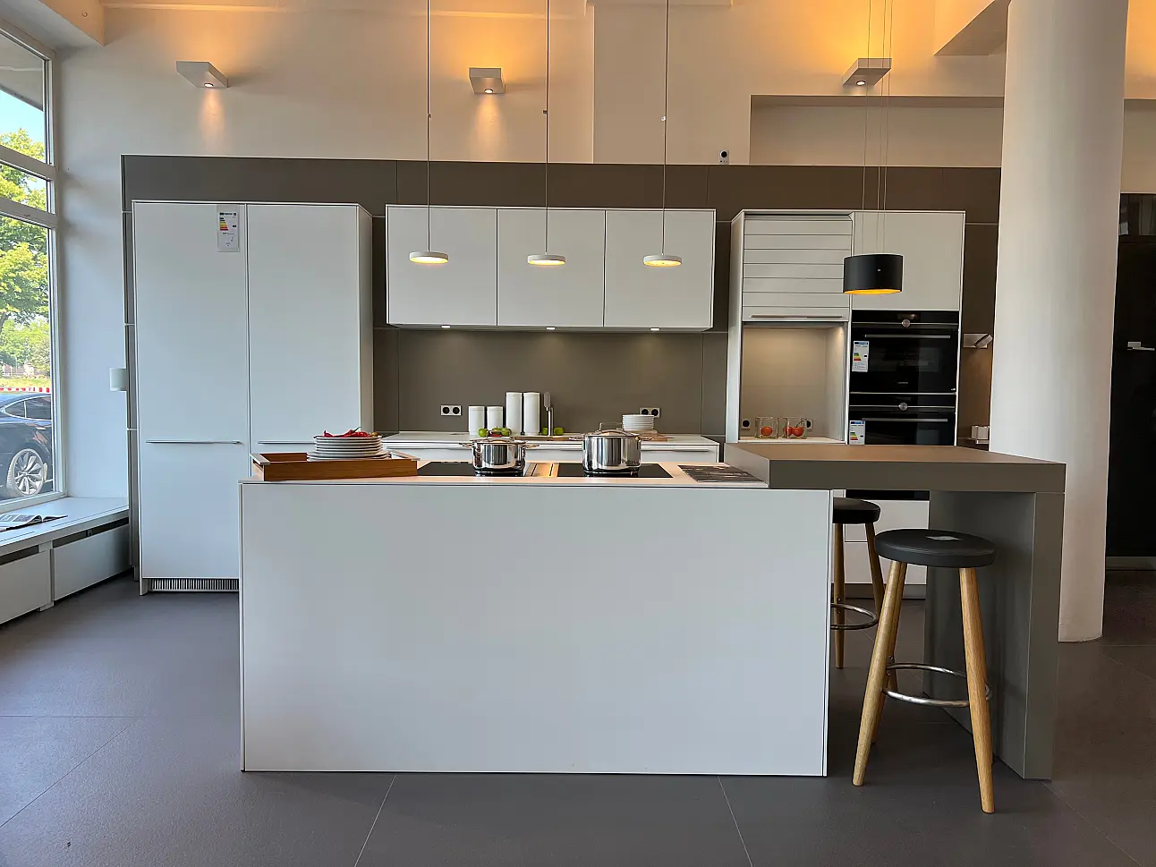 bulthaup b3 mit weißen Laminatfronten, Hochschrankwand und Insel mit Theke in Lübeck