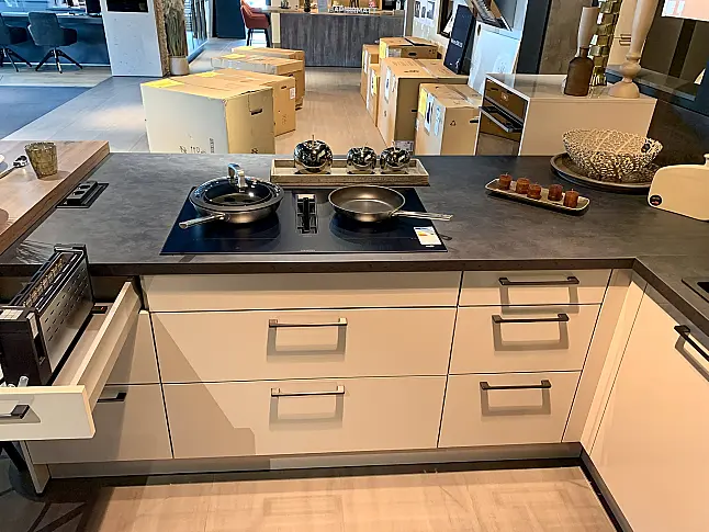 moderne Küche in T-Form mit Theke, schwarzem Siemens Backofen und Muldenlüfter aus satiniertem Glas