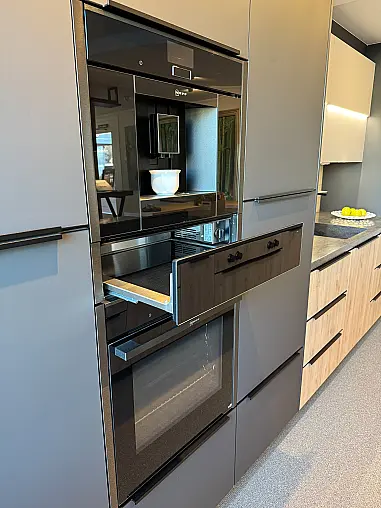 Moderne, elegante Einbauküche mit Wandzeile, Kochinsel, Baransatz und rückwertigem Sideboard, sowie Arbeitsplatte aus Corian-Mineralwerkstoff