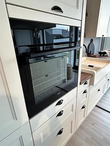Elegante Landhausküche mit Insel und Buffet-Schrank, crema-magnolie