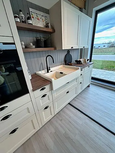 Elegante Landhausküche mit Insel und Buffet-Schrank, crema-magnolie