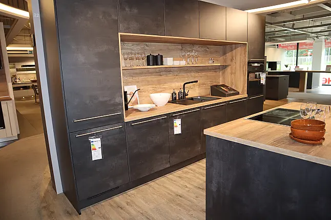 Grifflose Nobilia-Küche in Dunkel mit Holz-Arbeitsplatte und Nischenrückwand