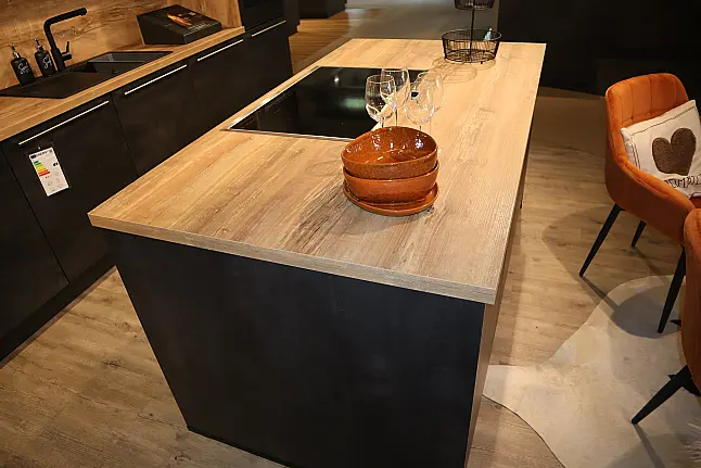Grifflose Nobilia-Küche in Dunkel mit Holz-Arbeitsplatte und Nischenrückwand