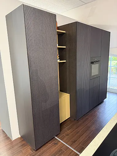 Moderne, grifflose Ausstellungsküche in zwei Farben mit Insel und Miele Geräten