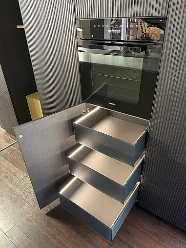 Moderne, grifflose Ausstellungsküche in zwei Farben mit Insel und Miele Geräten