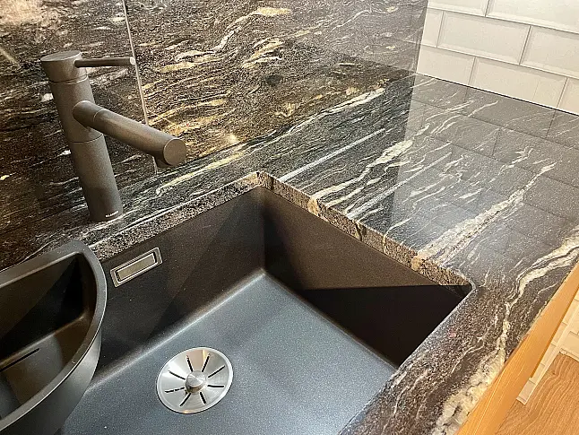 Küche in Fräsrillen-Optik mit Naturstein-Arbeitsplatte