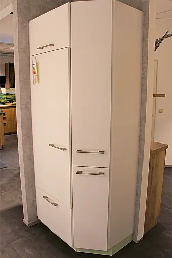 Gemütliche L-Küche mit extra Geräte-Hochschrank für den Kühlschrank in moderner Kombination: Krsitallweiß matt, mit Massiver Steinplatte sowie Farbakzenten in Pastellgrün