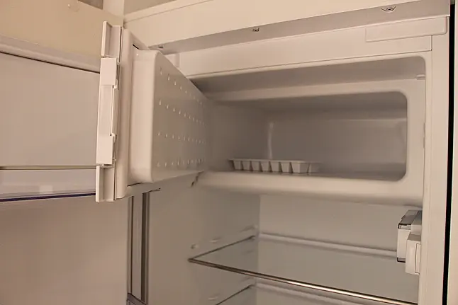 Gemütliche L-Küche mit extra Geräte-Hochschrank für den Kühlschrank in moderner Kombination: Krsitallweiß matt, mit Massiver Steinplatte sowie Farbakzenten in Pastellgrün