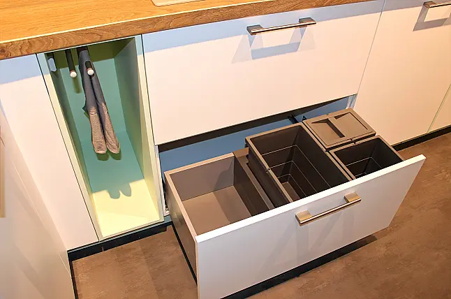 Gemütliche L-Küche mit extra Geräte-Hochschrank für den Kühlschrank in moderner Kombination: Krsitallweiß matt, mit Massiver Steinplatte sowie Farbakzenten in Pastellgrün