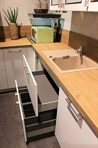 Gemütliche L-Küche mit extra Geräte-Hochschrank für den Kühlschrank in moderner Kombination: Krsitallweiß matt, mit Massiver Steinplatte sowie Farbakzenten in Pastellgrün