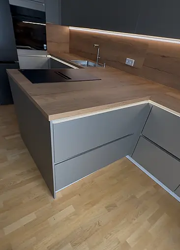 Moderne Designküche mit hochwertigen Polimerglas-Fronten in Sandgrau Metallic. Die warme Resopal-Arbeitsplatte in Alteiche Natur sorgt für einen edlen Kontrast und eine natürliche Ausstrahlung. Besondere Akzente setzt die elegante LED-Griffbeleuchtung.