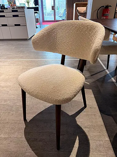 Moderner Polsterstuhl mit hochwertigem Bouclé-Bezug in warmem Creme-Ton.