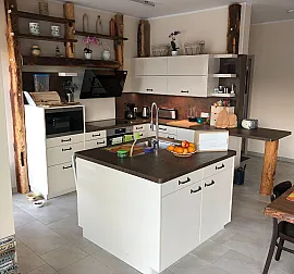Küche mit Insel und Altholz-Balkenkonstruktion