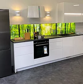 Polarweiß lackierte Küchenfronten mit beleuchteter Glasmotivrückwand und gepolsterte Sitzecke