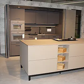 Moderne Ausstellungsküche von next125 mit Kochinsel in Saharabeige und Pocketsystem