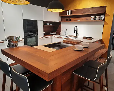 Linee in Nussbaum · hochwertige Vollholzküche in Nussbaum mit Fronten in Glas naturweiss