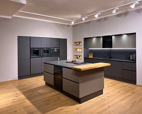 HIGH-END-GERÄTE wie Pyrolyse-Backofen mit 300° Pizzastein, Kombidampfgarer (beide m. Kernthermometer), Kaffeeautomat, 2 Wärmeschubladen, Performance-Muldenlüfter mit führendem Filtersystem, Teppan, großer Kühlschrank, extra Gefrierer, 2-Zonen-Weinkühler! - GROßE LUXUSKÜCHE ALS GESAMTKUNSTWERK. Sündhaft teure & traumhaft elegante Materialien: Smartglasfronten in Lava und Taupe, geflammter afrikanischer Naturstein,Theke und Einsätze in Eiche, Ausziehtablar für Küchenmaschine,Vitrinenschrank,App-steuerbare LED