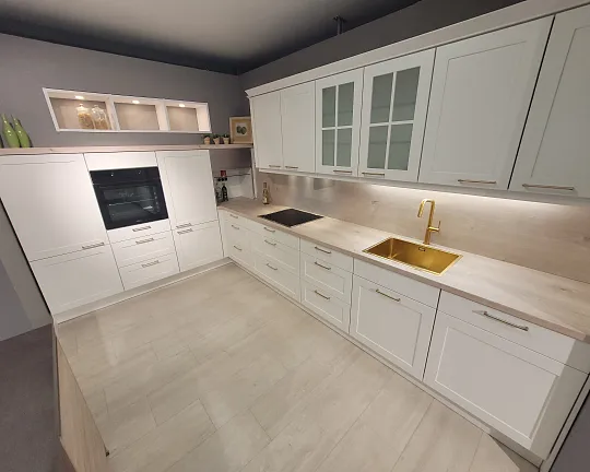 moderne Landhausküche mit goldenen Akzenten - weiße Rahmenfront mit heller Eiche Arbeitsplatte