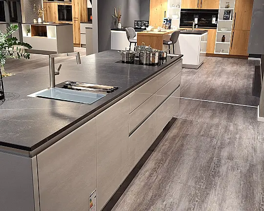moderne Grifflos-Inselküche mit Glasfronten und Dekton Keramikarbeitsplatte - Modell Y-PS Organic glanzhellgrau +MP Walnuss ultramtt