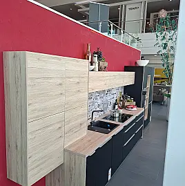 Moderne Ausstellungsküche mit Fronten in Lacklaminat Schwarz supermatt und einer pflegeleichten Arbeitsplatte in Eiche San Remo Nachbildung. Inklusive hochwertiger Elektrogeräte von Neff, Franke-Spüle und sofortiger Verfügbarkeit zur Abholung.
