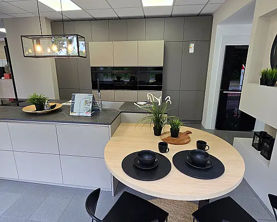 Moderne Wohnküche in edlen Naturtönen - FEEL: Basalt & Taupe matt kombiniert mit Tischlösung in EICHE NATUR und Keramik Arbeitsplatte