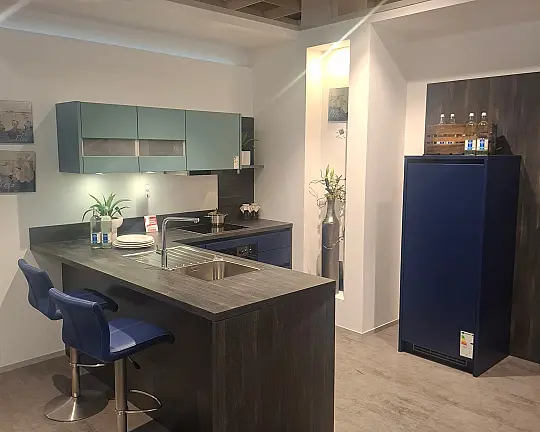 Moderne L-Küche mit freistehender Insel, Fronten in Aquablau-Satin und markanter Castelleiche-Optik - Biella - Aquablau-Satin / Castelleiche anthrazit Nachb. (Programm BIE) -Koje 083-