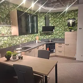 Warme L-Küche in Asteiche Natur mit eleganten schwarzen Akzenten und praktischem Ansetztisch