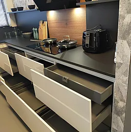 Greeploze witte hoogglans keuken met houtdecor accenten en koolstofzwart werkblad