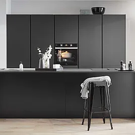 moderne, grifflose Einbauküche in schwarz mit Elektrogeräten