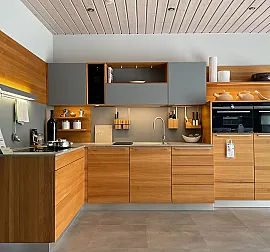 moderne Massivholzküche in Eiche abgesetzt mit matt grauer Glasfront und Keramik-Arbeitsplatte