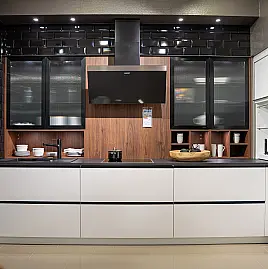 Häcker concept130 grifflose Küche in Kristallweiß – L-Form mit Riffelglas-Vitrinen, Miele & AEG Induktion | Ausstellungsküche