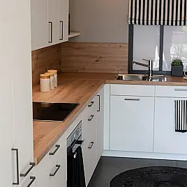 Zeitlose Design Küche in L-Form in Kristallweiß Mattlack, durchdachte Stauraumlösungen und hochwertige Markengeräte