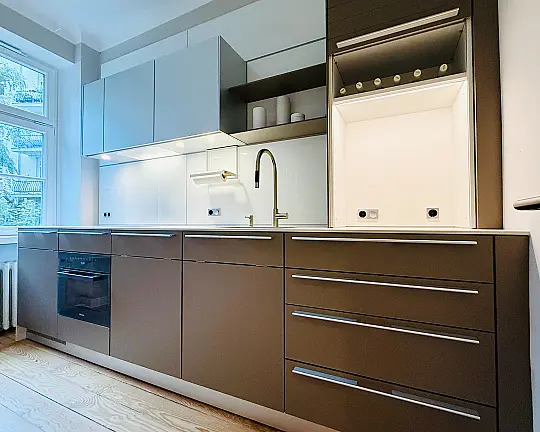 "elegante Küchenzeile mit hochwertiger Ausstattung und kostbaren Materialen bzw. Details" - Serie b3  mit Fronten in Laminat lehm / Oberschränke in alu natur / Paneele in glas weiß