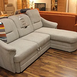Schlichte hellgraue Couch verbirgt praktische Funktionen und kommt zusammen mit passendem Sessel auf Rollen