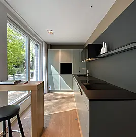 L-Zeile in Mattlack Eukalyptus mit Dekton-Arbeitsplatte
