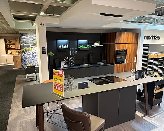 Musterküche aus Koje 109 im Wohnkaufhaus Krefeld - Zeile + Insel in Dekor NX870 Fenix onyxschwarz / NX650 Lärche geräuchert geb.