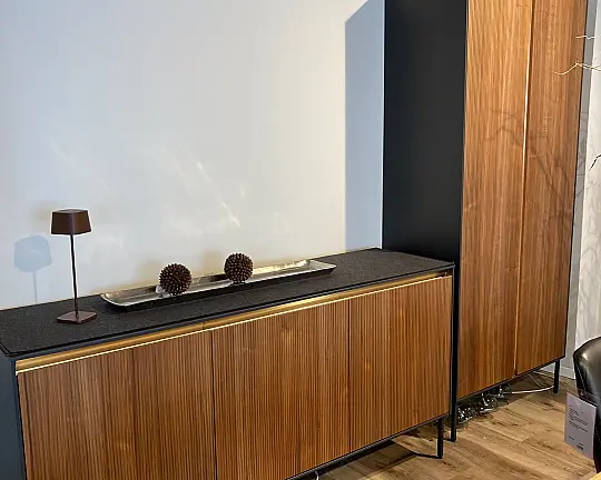 pronorm Q-EI Nussbaum natur Griffleiste Messing gebürstet und beleuchtet, steht auf Metallgestell anthrazit - Q-EI Nussbaum natur Griffleiste Messing gebürstet und beleuchtet